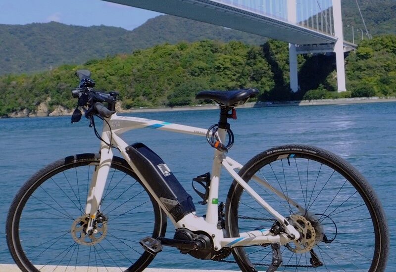 Bicycle in a beach with one of the bridges in Shimanami Kaido